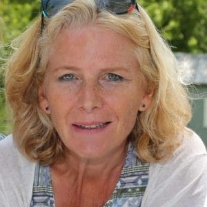 Ginny Jewiss smiling with glasses sitting on her head.