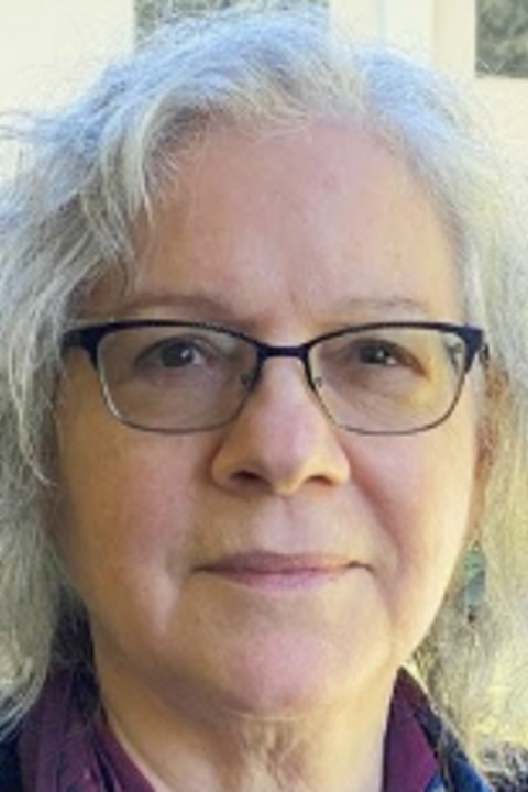 A photograph of Nancy Harrowitz, with short white hair and black-rimmed glasses.
