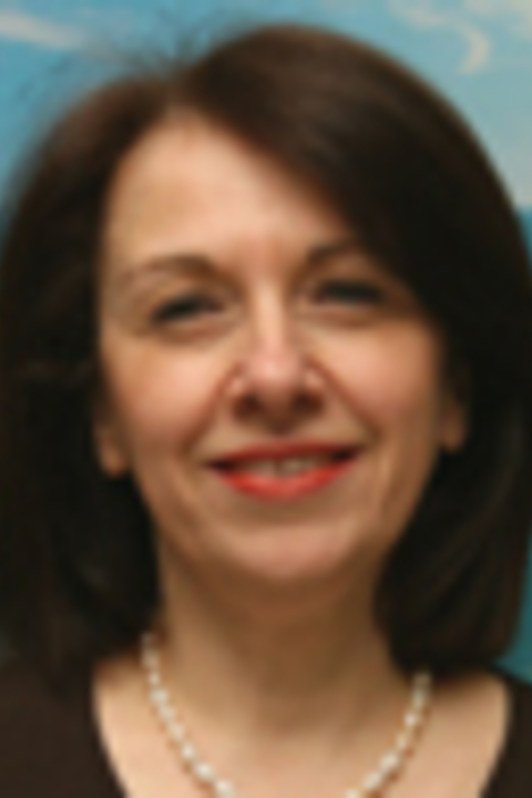 Antonella Ansani with shoulder length brown hair, wearing pearl necklace, brown shirt.