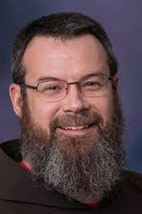 smiling, wearing glasses, long beard and mustache