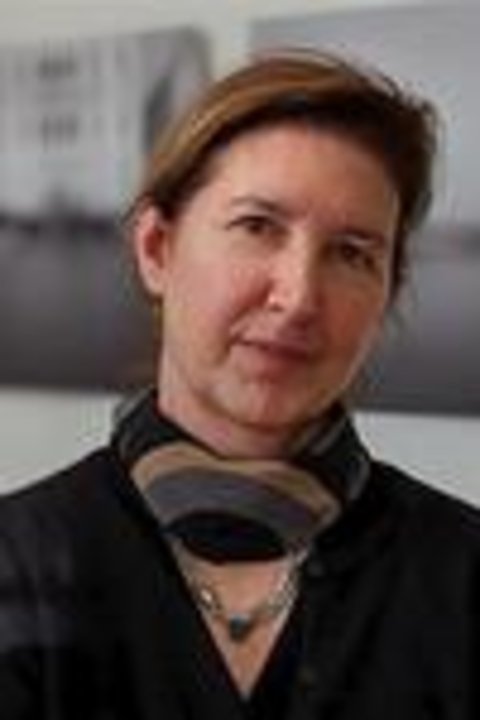 Adrienne Defendi wearing a scarf tightly fitted around her neck, black v neck shirt