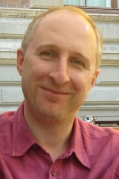 Marcello Simonetta smiling, wearing a burgundy cotton shirt on a sunny day