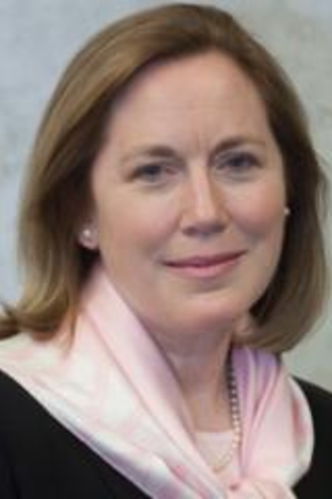 Mary Ann Carolyn wearing a pink scarf, black shirt and pearl earrings.