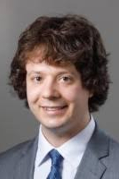 Griffin Oleynick wearing a blue suit with a white shirt and blue tie